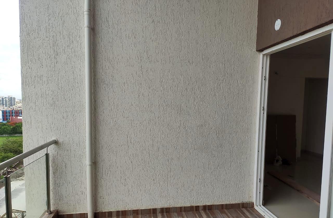 The balcony at handover — bare plaster and screed, with the railing the only finished edge