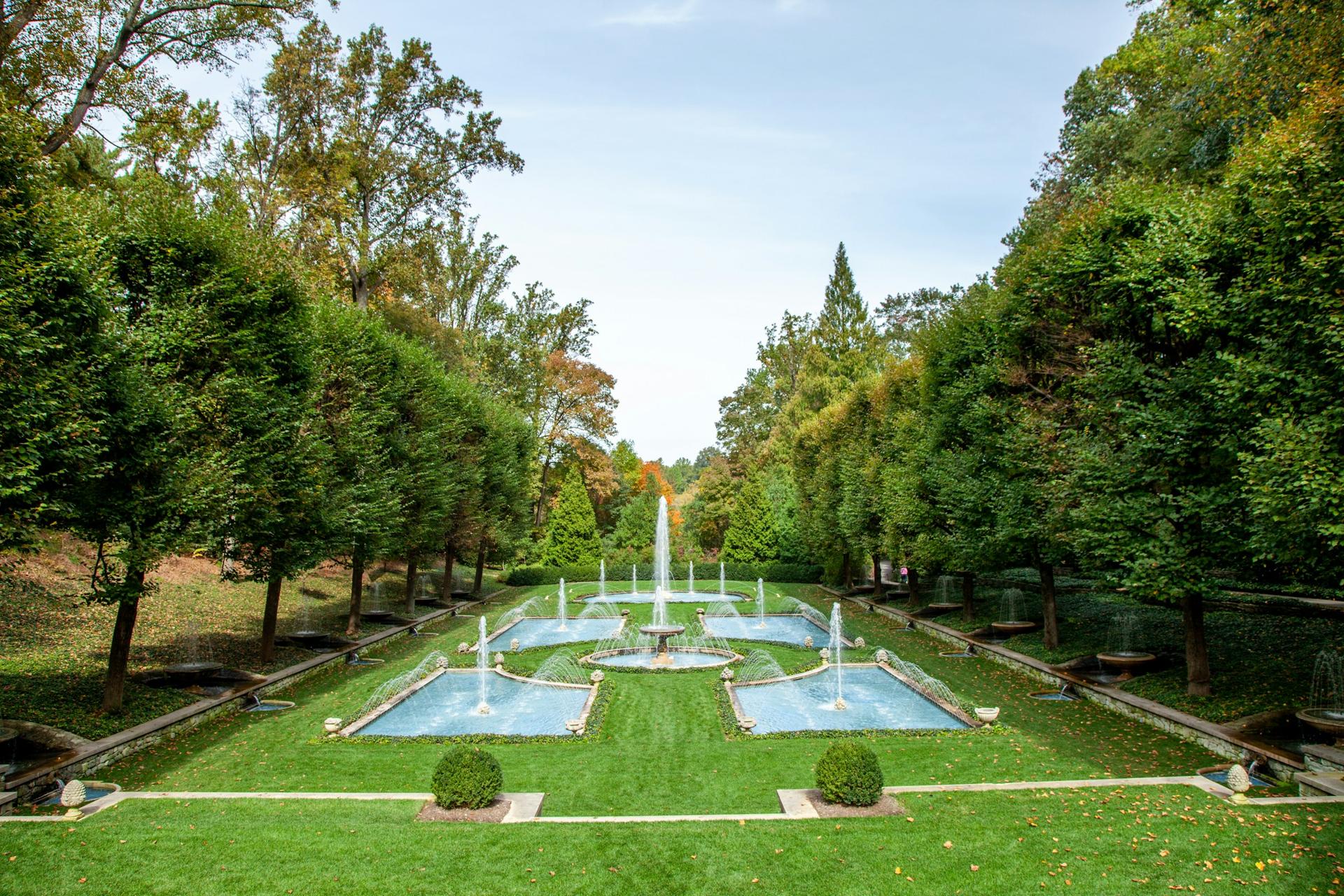 A long reflecting pool set within a formal lawn and clipped hedging